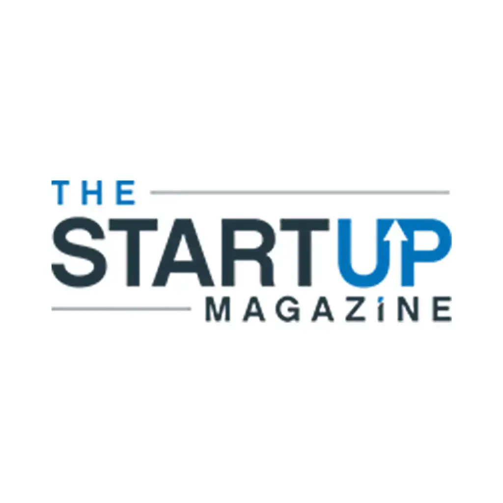 Blue and dark-gray wordmark “THE STARTUP MAGAZINE,” upward-pointing arrow forming part of the “U,” separated by thin gray lines on white.