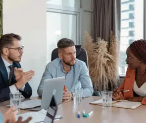 Diverse business team in a formal boardroom discussing strategy during a design entrepreneurship meeting.