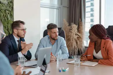 Diverse business team in a formal boardroom discussing strategy during a design entrepreneurship meeting.