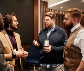 Group of male design entrepreneurs networking and discussing ideas for partnership at a business conference.