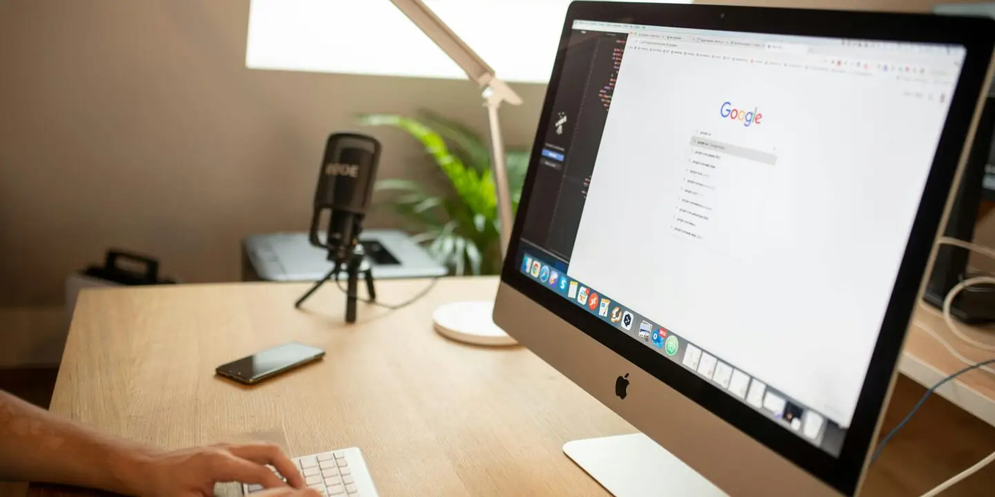 Design entrepreneur using an iMac to conduct SEO keyword research on Google
