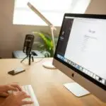 Design entrepreneur using an iMac to conduct SEO keyword research on Google