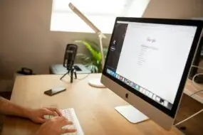 Design entrepreneur using an iMac to conduct SEO keyword research on Google