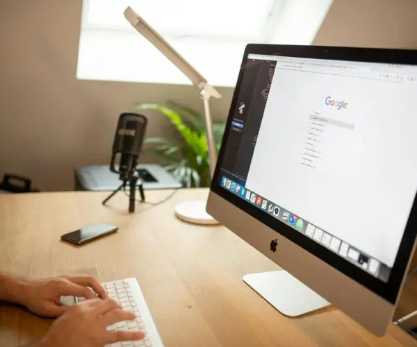 Design entrepreneur using an iMac to conduct SEO keyword research on Google