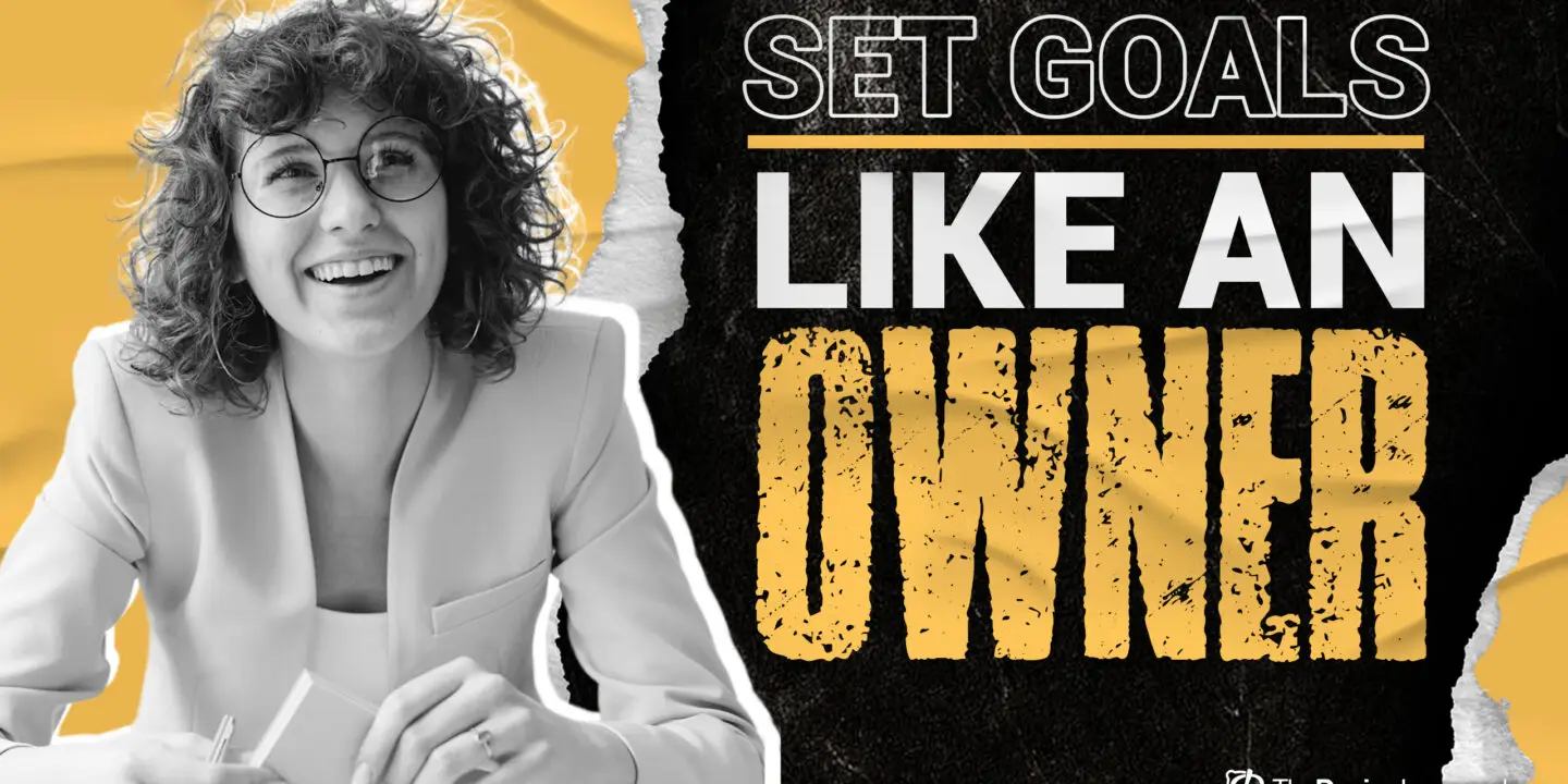 Smiling creative professional sitting at a desk with the motivational phrase “Set Goals Like an Owner,” representing a mindset shift for design entrepreneurs to build and scale successful design businesses.