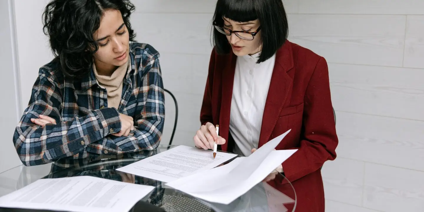 Professionals reviewing and signing contract documents, representing legally binding agreements for a design business.