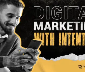 Designer using smartphone beside text “Digital Marketing With Intention.”