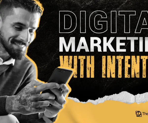 Designer using smartphone beside text “Digital Marketing With Intention.”