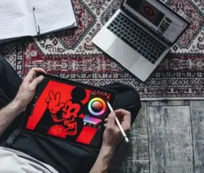 Designer creating digital illustration on tablet workspace.