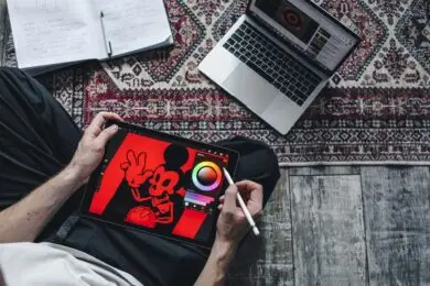 Designer creating digital illustration on tablet workspace.