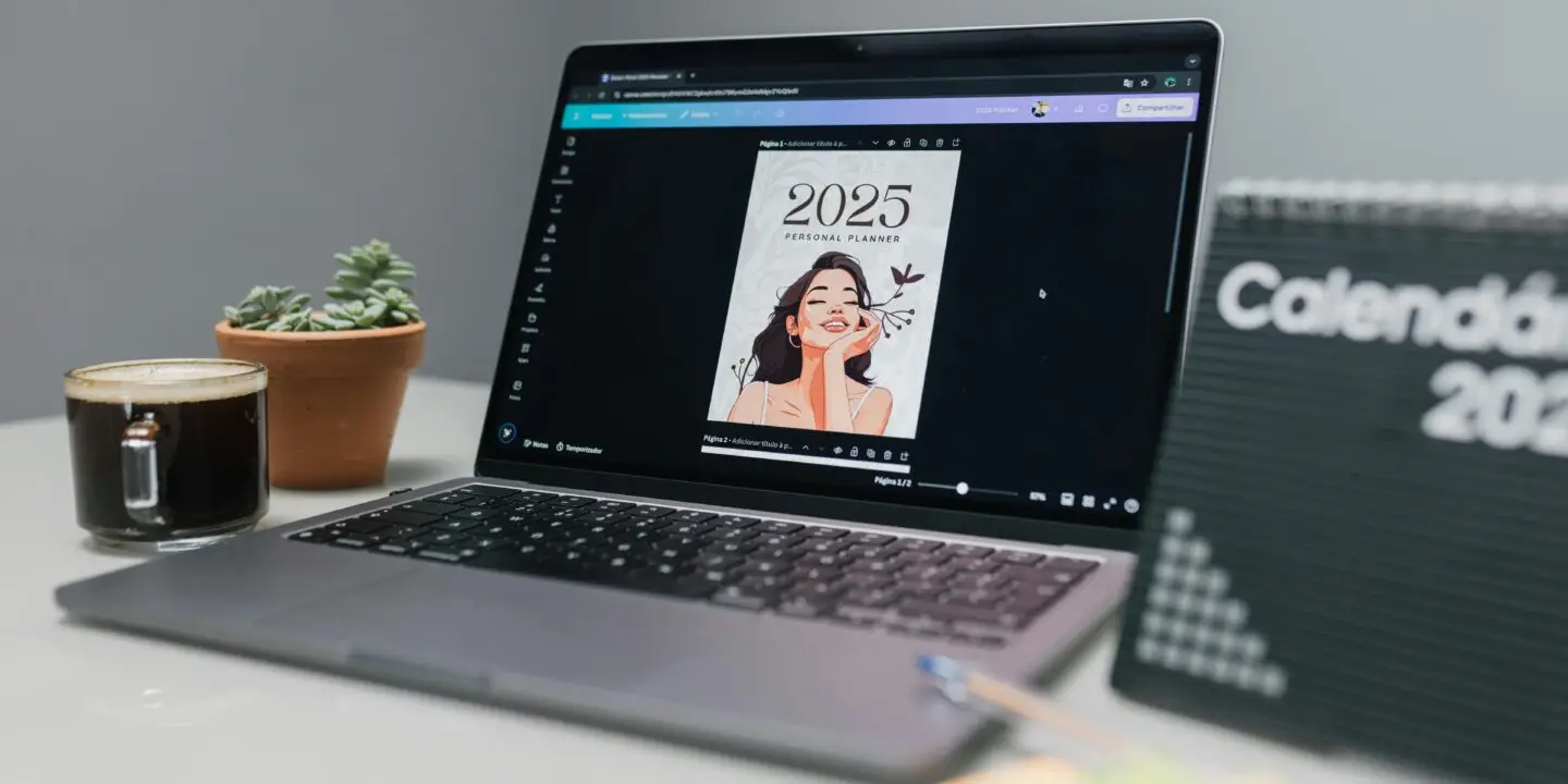 Laptop displaying a Canva-designed 2025 personal planner template on a desk with coffee, plant, and calendar board.