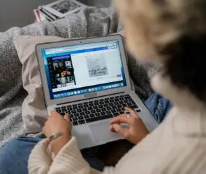 Designer editing Canva templates on laptop while working from home.