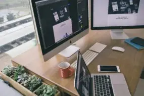 Professional design workspace with multiple screens showing website and digital product development.