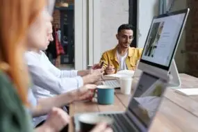 Creative team collaborating in a meeting to discuss digital design projects and licensing opportunities.