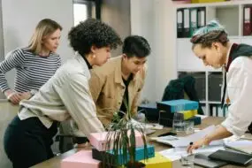 Group of professionals reviewing documents and collaborating around a table in an office workspace.