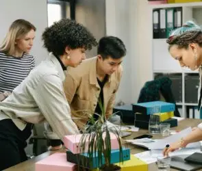 Group of professionals reviewing documents and collaborating around a table in an office workspace.