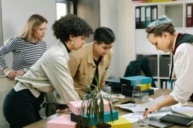 Group of professionals reviewing documents and collaborating around a table in an office workspace.