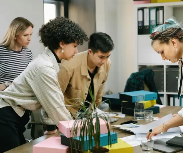 Group of professionals reviewing documents and collaborating around a table in an office workspace.