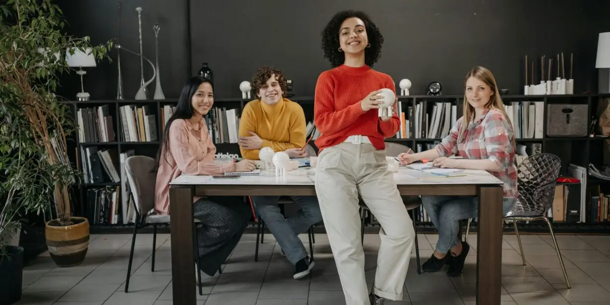 Group of creative professionals collaborating around a table in a modern workspace.