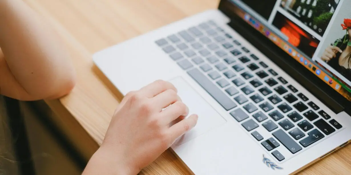 Designer browsing and organizing digital creative assets on a laptop for online product management and marketing.