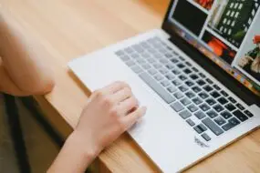 Designer browsing and organizing digital creative assets on a laptop for online product management and marketing.