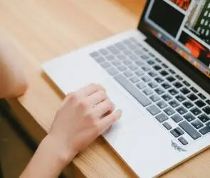 Designer browsing and organizing digital creative assets on a laptop for online product management and marketing.