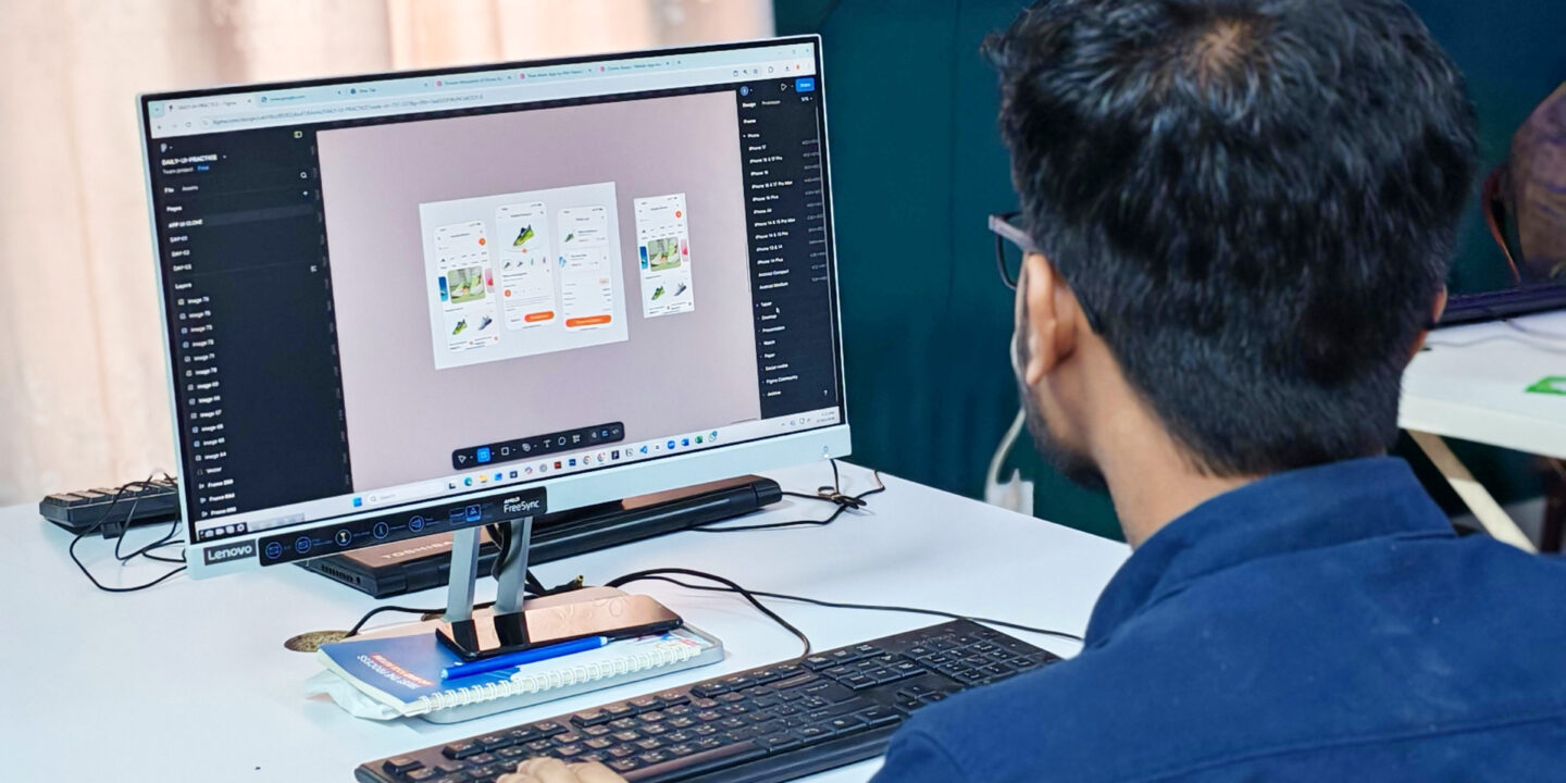 Designer working on digital mobile app interface designs on a desktop computer monitor.
