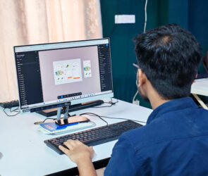 Designer working on digital mobile app interface designs on a desktop computer monitor.