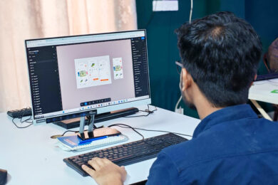 Designer working on digital mobile app interface designs on a desktop computer monitor.