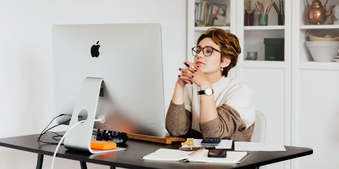 Designer reviewing work and business performance metrics at a desktop computer.