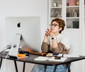 Designer reviewing work and business performance metrics at a desktop computer.