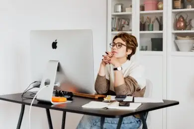 Designer reviewing work and business performance metrics at a desktop computer.